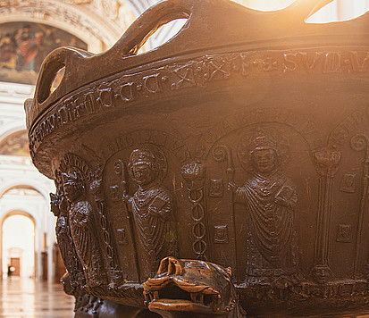 großes Becken aus Metall Löwenfüße stimmungsvolles Gegenlicht, Bronzebecken, Taufe, Dom Salzburg, romanisches Taufbecken